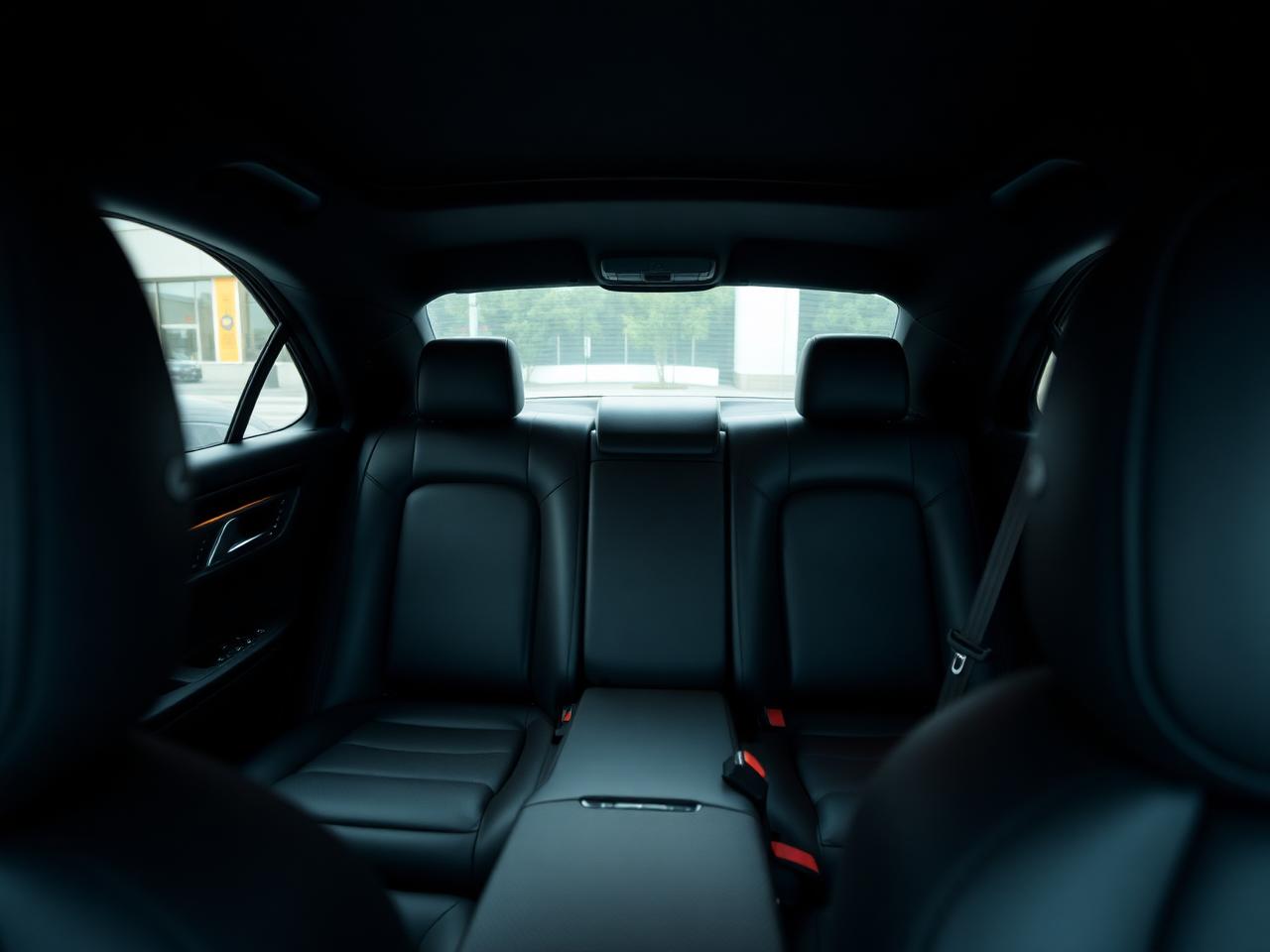 Interior de sedã executivo com bancos de couro escuro e iluminação suave